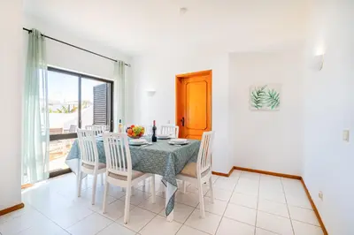 a dining room with a table and chairs and a window at Villa Maldives by Algarve Vacation in Montes Borralhos