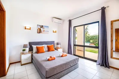 a bedroom with a bed with orange pillows on it at Villa Maldives by Algarve Vacation in Montes Borralhos