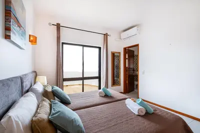 a living room with a couch and a large window at Villa Maldives by Algarve Vacation in Montes Borralhos