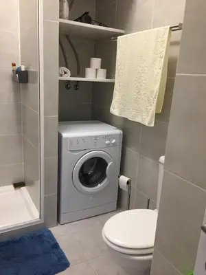 a bathroom with a washing machine and a toilet at Fully Renovated Studio in Albufeira