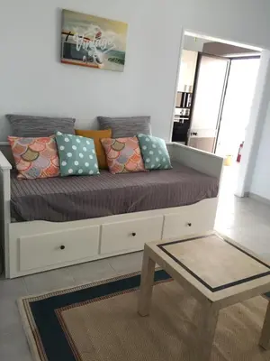 a couch with pillows and a table in a room at Fully Renovated Studio in Albufeira