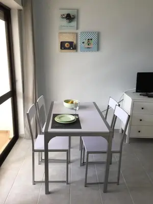 a dining room with a table with chairs and a bowl on it at Fully Renovated Studio in Albufeira
