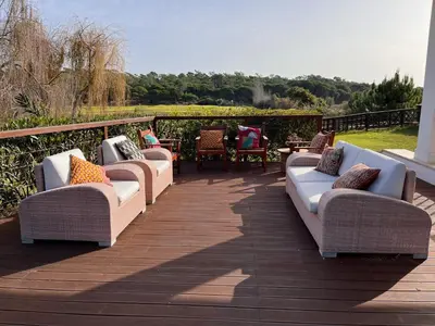 a row of couches sitting on a wooden deck at Villa Formosa Golf in Quinta do Lago