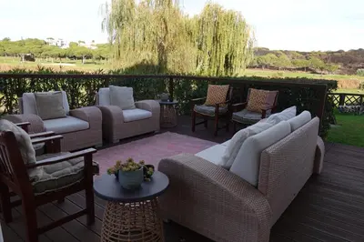 a patio with couches and chairs on a deck at Villa Formosa Golf in Quinta do Lago