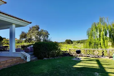 a backyard with a fence and a lawn at Villa Formosa Golf in Quinta do Lago