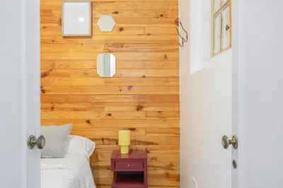 a bedroom with wooden walls and a bed with a lamp at The Central Townhouse in Faro