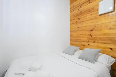 two white beds in a room with a wooden wall at The Central Townhouse in Faro