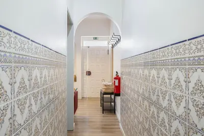 a hallway with white and blue tiled walls at The Central Townhouse in Faro