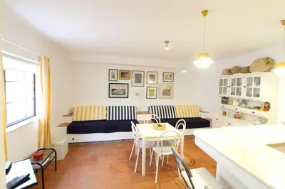 a living room with a staircase and a table and chairs at Fisherman's Townhouse at Old Town in Albufeira