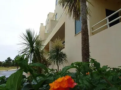 a building with palm trees and flowers in front of it at Apartment Salgados T1 in Guia