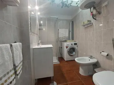 a bathroom with a toilet sink and a washing machine at Apartamento Quarteira T1 in Quarteira