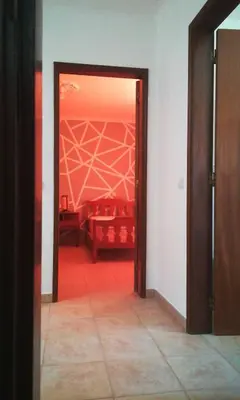 an open door to a room with a red floor at Holiday House in Albufeira