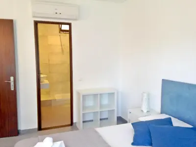 a bedroom with a bed and a door to a closet at Casa Balaia in Albufeira