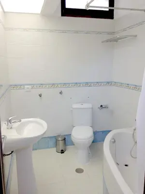 a white bathroom with a toilet and a sink at Casa Balaia in Albufeira