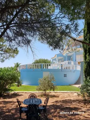 a table and chairs in front of a cruise ship at Villa Quinta da Violeta in Loulé