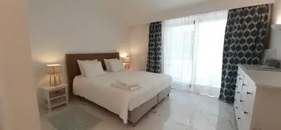 a bedroom with a large white bed with two lamps at Quinta do Lago Beach House in Quinta do Lago