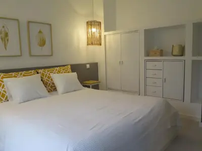 a bedroom with a white bed and a white cabinet at T4 Grand Townhouse Old Village in Vilamoura