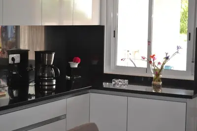 a kitchen with white cabinets and a black counter top at casa de ferias in Algoz