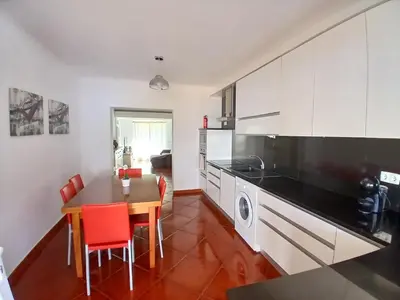 a kitchen with a table and a dining room at casa de ferias in Algoz