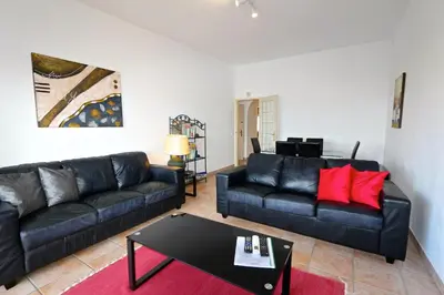 a living room with two black couches and a table at Marbel Sol - Clever Details in Vilamoura