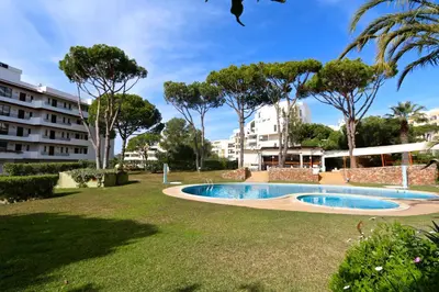 a swimming pool in a park with trees and buildings at Marbel Sol - Clever Details in Vilamoura