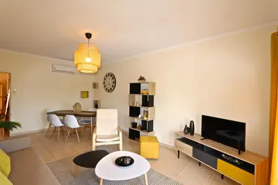 a living room with a television and a table at Marbel Sol - Clever Details in Vilamoura