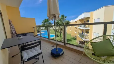 a balcony with a table and chairs and a pool at Apartamento luxo e sossego in Albufeira