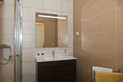 a bathroom with a sink and a mirror at Apartamento luxo e sossego in Albufeira