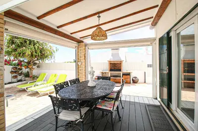 a patio with a table and chairs on a deck at Villa Tibouchina in Albufeira