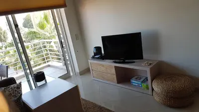 a living room with a flat screen tv on a cabinet at Apartamento Vilamoura in Quarteira