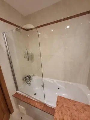 a bathroom with a tub with a glass shower at Apartamento Vilamoura in Quarteira