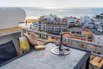a table with two glasses of wine on a balcony at Penthouse Sea View by Albufeira Holidays in Albufeira