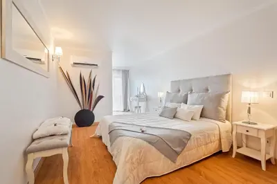 a white bedroom with a large bed and a chair at Penthouse Sea View by Albufeira Holidays in Albufeira