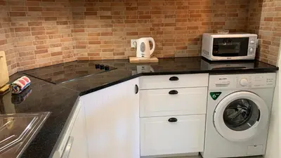 a kitchen with a washing machine and a microwave at Apartamento Bela Vista in Albufeira