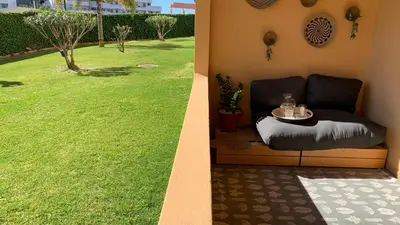 a couch sitting next to a green grass yard at Apartamento Bela Vista in Albufeira