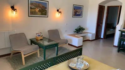 a living room with two chairs and a table at Apartamento Bela Vista in Albufeira