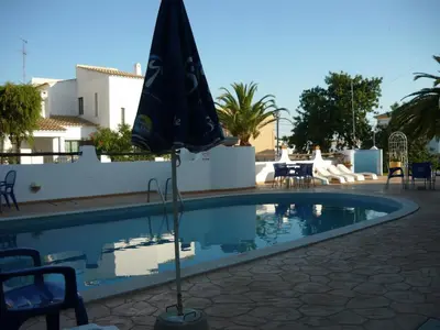 an umbrella sitting next to a swimming pool at Agua Marinha ROSA- Hotel in Albufeira