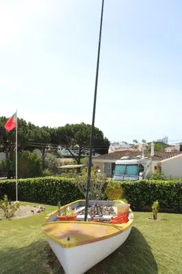 a boat sitting on the grass in a yard at Agua Marinha ROSA- Hotel in Albufeira