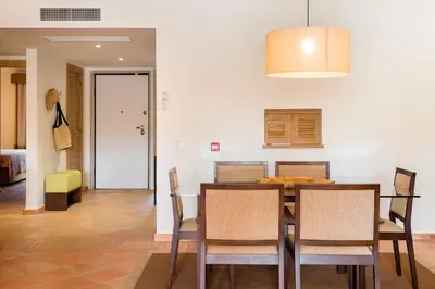 a kitchen and dining room with a table and chairs at Birdsong Vila Sol Village in Vilamoura