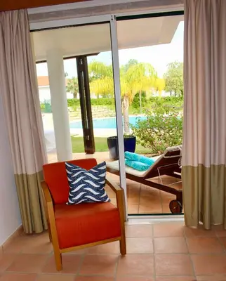 a room with a chair and a sliding glass door at Birdsong Vila Sol Village in Vilamoura
