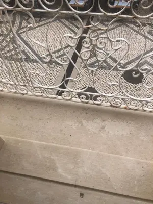 a metal bench sitting on top of a sidewalk at Maria Guest house in Albufeira