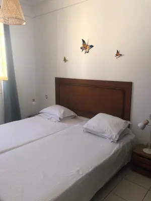 two beds in a bedroom with butterflies on the wall at Maria Guest house in Albufeira
