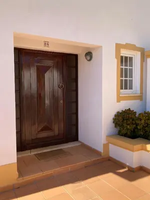 a wooden door in the corner of a room at Moradias Villas Rufino in Albufeira