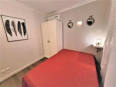 a small room with a red bed in it at Ritta's house in Albufeira