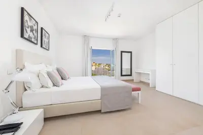 a white bedroom with a bed and a desk at Eden Villas & Apartments in Albufeira