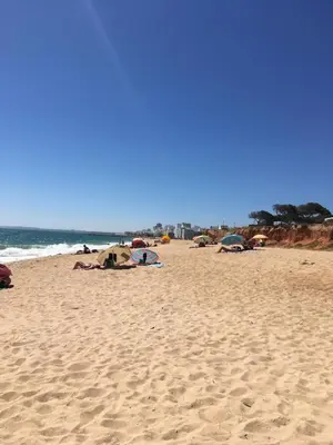 a beach with people laying on the sand at Boa Vida in Quarteira