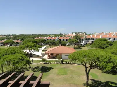 a park with benches and trees and buildings at Boa Vida in Quarteira