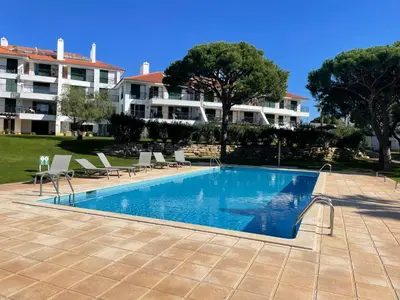 a swimming pool in front of a large building at Boa Vida in Quarteira