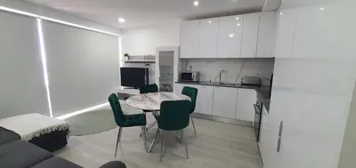 a kitchen and living room with a table and chairs at ACR Holiday Apartment in Quarteira