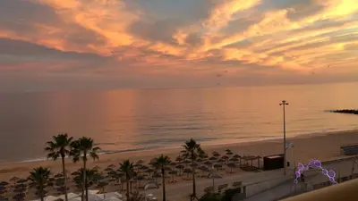 a view of the beach and the ocean at sunset at ACR Holiday Apartment in Quarteira
